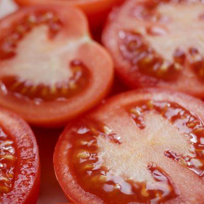 Vibrant close-up of fresh red tomato slices for healthy food concepts.